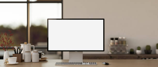 istock Cosy home workspace with a white-screen computer mockup and accessories on a wooden desk. 1851148672