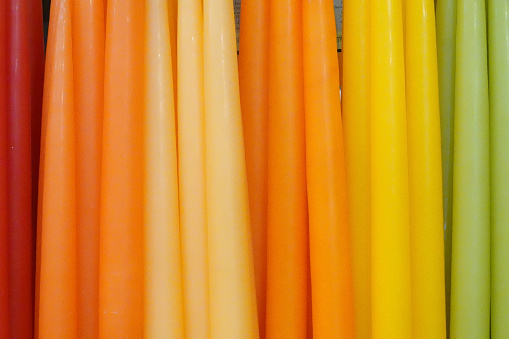 A line of colorful candles hanging in a store.