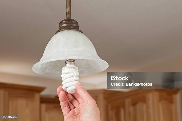 Foto de Mãos Instalando Com Lâmpadas Fluorescentes Compactas e mais fotos de stock de Lâmpada de poupança de energia