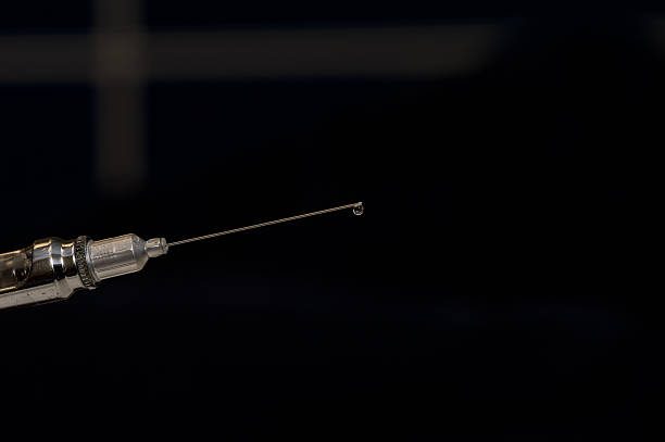 Used syringe on a black background stock photo