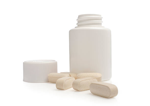 aberto frasco de comprimidos com pílulas esparsas - bottle vitamin pill nutritional supplement white - fotografias e filmes do acervo