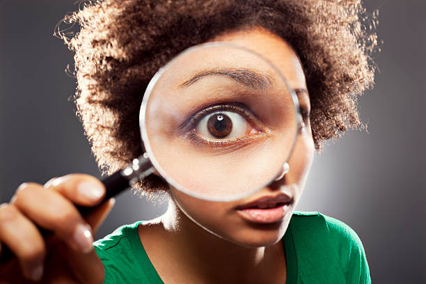 Young woman with a loupe Young woman with a magnifying glass magnifying glass photos stock pictures, royalty-free photos & images