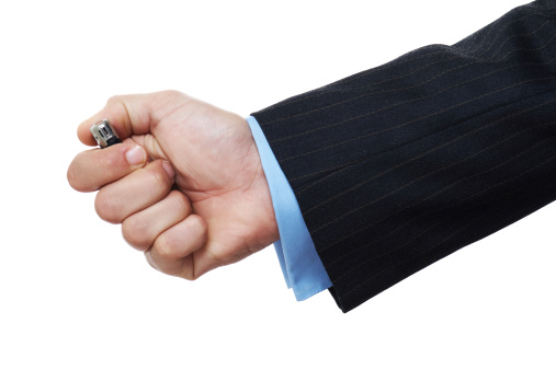 Hand of a man in suits lighting a cigarette lighter