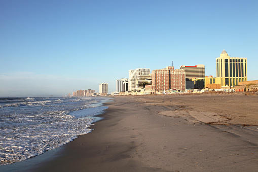 Atlantic City skyline hotel casinos along the beach. Atlantic City located on the Jersey shore is a resort city on Absecon Island  in Atlantic County, New Jersey. Atlantic City is known for its two mile long boardwalk, gambling casinos, great nightlife, beautiful beaches, and the Miss America Pageant.