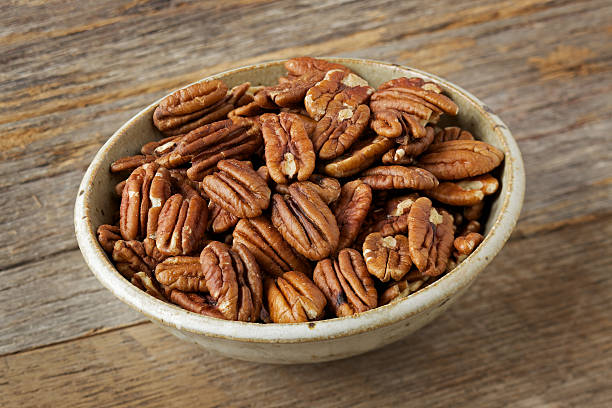 istock Bowl of pecan nuts on old wood table 185117194