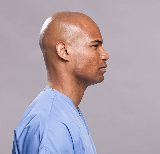 Medical Patient Side Profile-Facing Right Side profile portrait of an african american male dressed in blue scrubs. He could be a doctor, nurse, lab technician, or patient. doctor head stock pictures, royalty-free photos & images