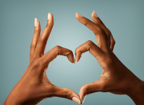 Close up shot of an African female hands making a heart shape.