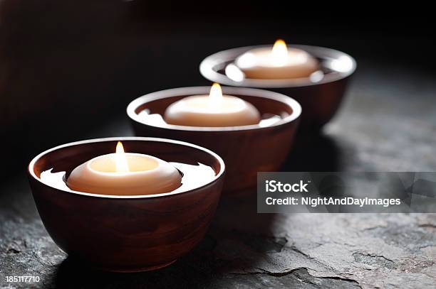 Three Lit Candles Floating In Wooden Bowls Filled With Water Stock Photo - Download Image Now
