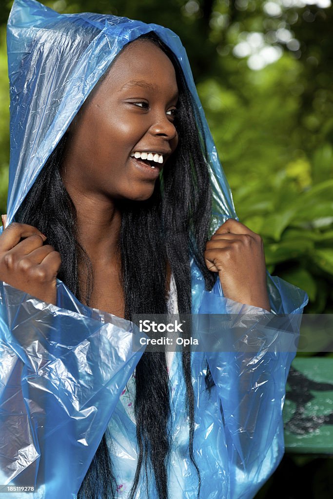 Smiling young woman in blue rain poncho 20-24 Years Stock Photo