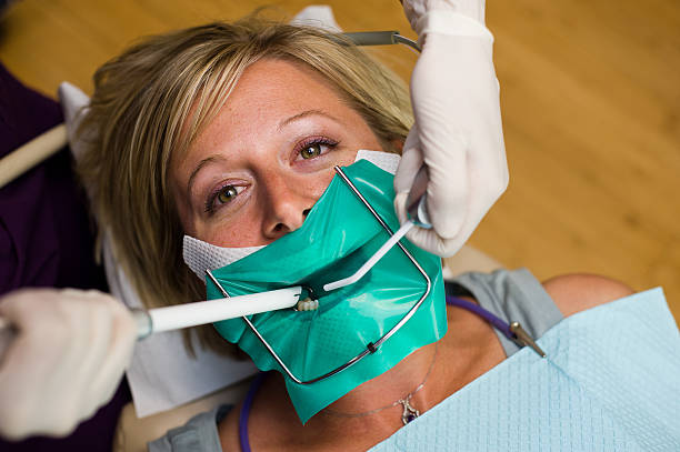 Patient in Dental Chair getting a cavity filled stock photo