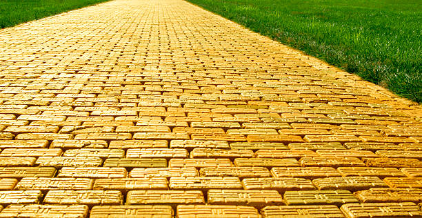 yellow brick road-широкий - brick yellow road footpath стоковые фото и изображения