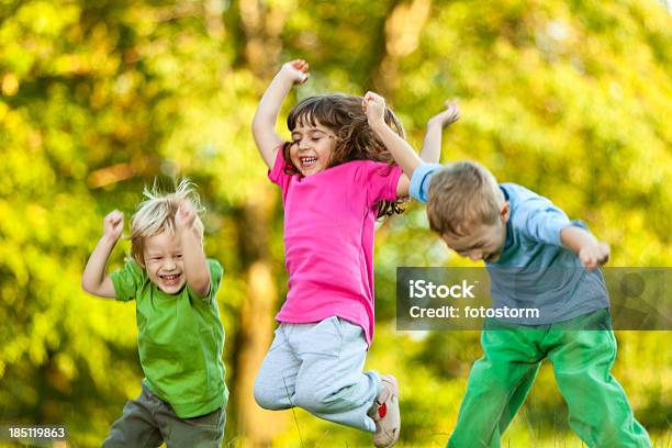 Gruppe Von Drei Glückliche Kinder Springen Im Freien Stockfoto und mehr Bilder von Hochspringen