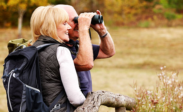 istock Couple of hikers looking away through binoculars 185120460