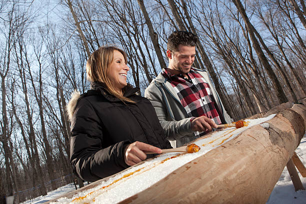 istock couple eat Maple taffy on a sunny day 185120826