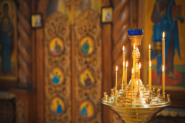 Burning candles in a Russian ortodox church. Close-up of ordinary church interior. Selective focus.