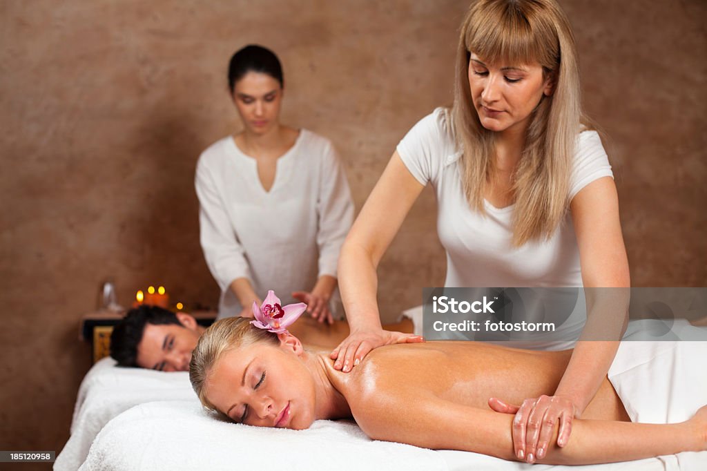Terapisti dando un massaggio di coppia alla spa - Foto stock royalty-free di Adulto