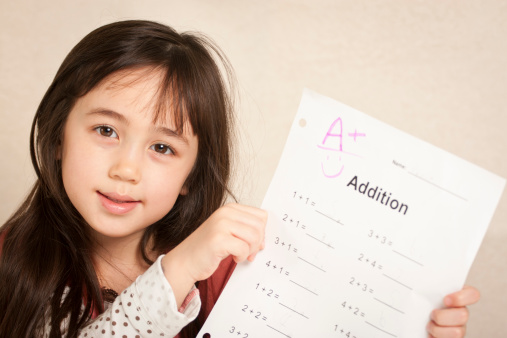 Kindergarten-aged girl is happy with her grade on math test or assignment.See others from this series: