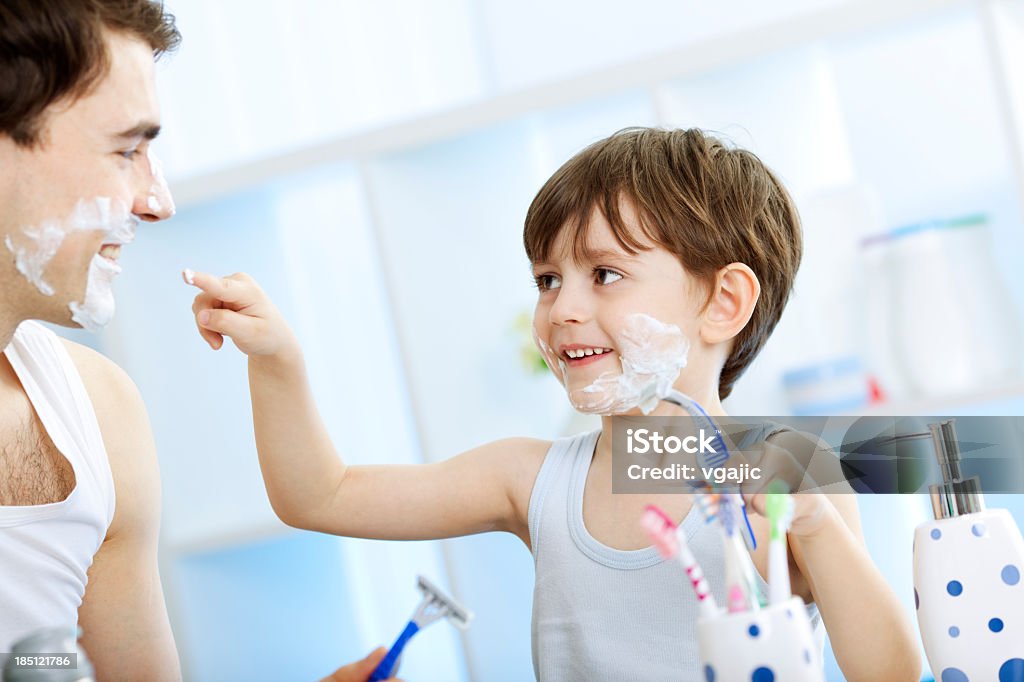 Father and his son shaving in the bathroom. Father and son having fun in the bathroom with shaving foam Father Stock Photo