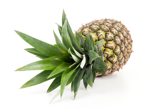 Pineapple on white background. Top view across leaves. Selective focus.