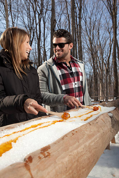 istock couple eat Maple taffy on a sunny day 185122344