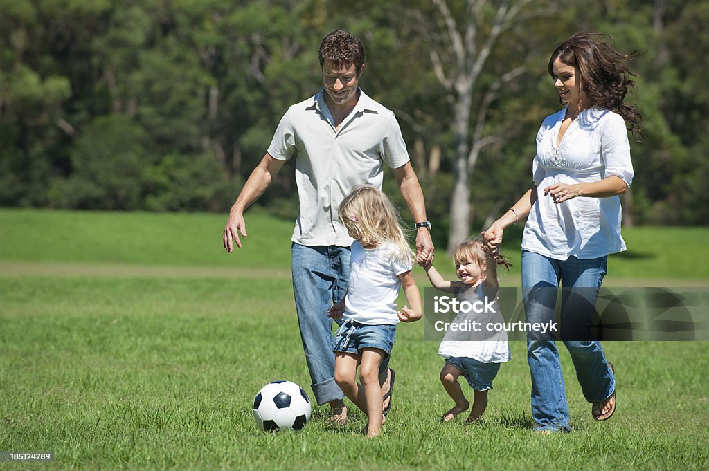 Famille heureuse jouant avec un ballon de football - Photo de 18-23 Mois libre de droits