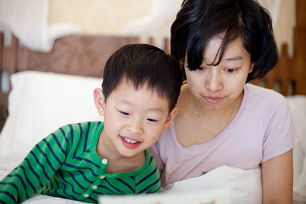 istock boy and mother reading book on bed 185124340