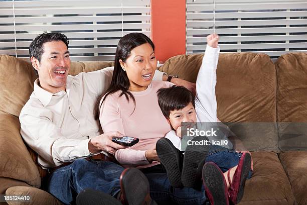 Familia Sentada En El Sofá Viendo Televisión Foto de stock y más banco de imágenes de 30-39 años - 30-39 años, 40-49 años, 6-7 años