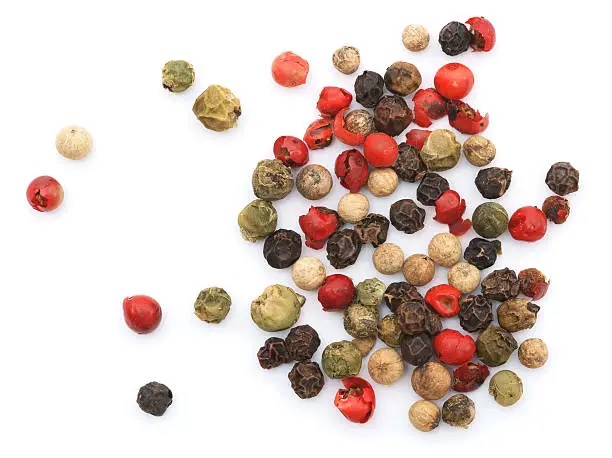 Mixed peppercorns pile isolated in white