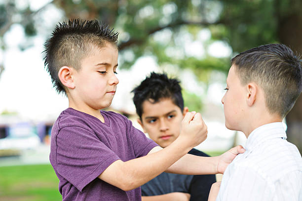 istock young bully holding up fist to kid 185124501