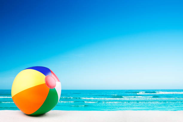 Beach ball on the beach on a clear sunny day A beach ball on a beautiful beach in summer. A seamlessly stitched panoramic image. beach ball beach summer ball stock pictures, royalty-free photos & images