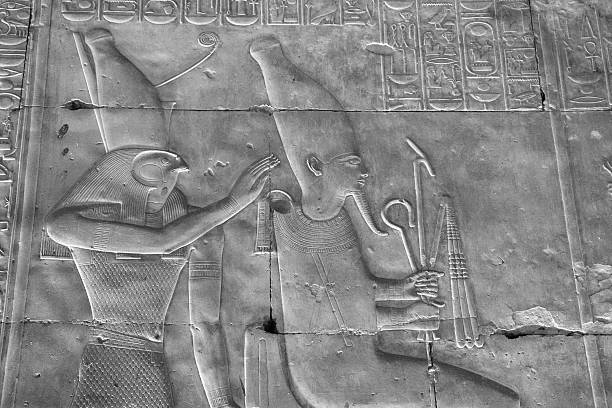 Horus and Osiris, Temple of Seti I, Abydos, Egypt "Raised relief, or bas relief, depicting the falcon god Horus, on the left, and Osiris.  Horus wears the double crown of Egypt (the Pschent) while Osiris wears the white crown (or Hedjet) of Upper Egypt.  The relief is located within the inner hypostyle hall and is of the highest quality.  Begun by Seti I but completed by his son, Ramesses II the temple of Seti I at Abydos is one of the finest buildings in Egypt." abydos stock pictures, royalty-free photos & images