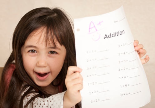 Kindergarten student ecstatic at her good grade on math.See others from this series: