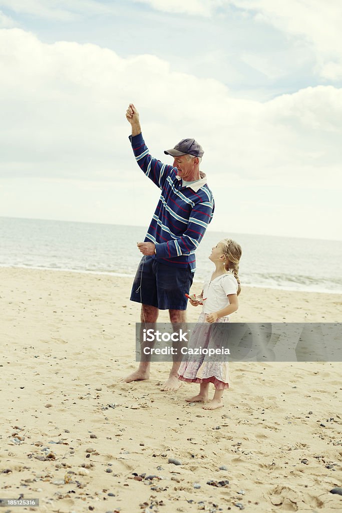 Little Girl e nonno di volare aquiloni sulla spiaggia - Foto stock royalty-free di Mare