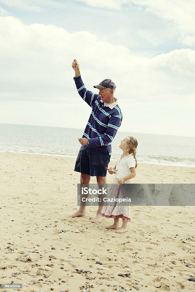 Dziewczynka latający latawiec z Grandad na plaży - Zbiór zdjęć royalty-free (Morze)