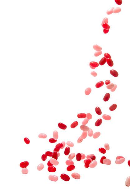 falling red and pink jelly beans on white background