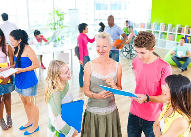 Students discussing with teacher.  common room stock pictures, royalty-free photos & images