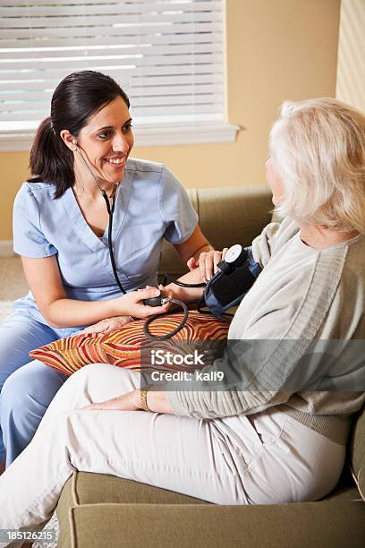 Enfermeira Tomando Pressão Arterial De Mulher Idosa - Fotografias de stock e mais imagens de 30-39 Anos
