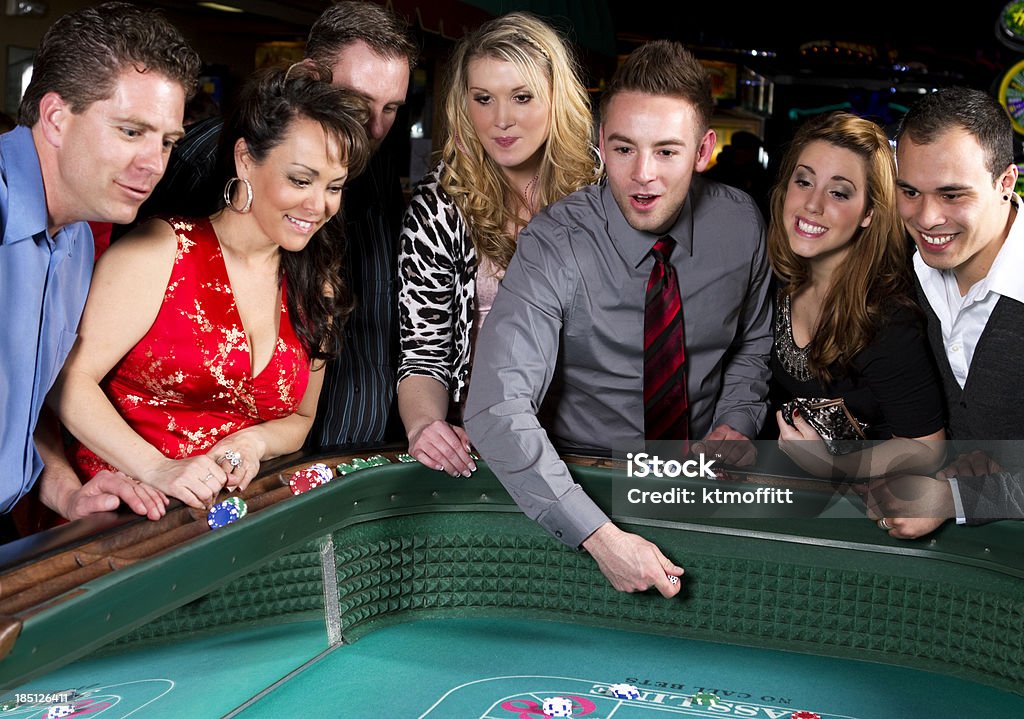 Happy Group Of Adults Gambling At Craps Table Stock Photo
