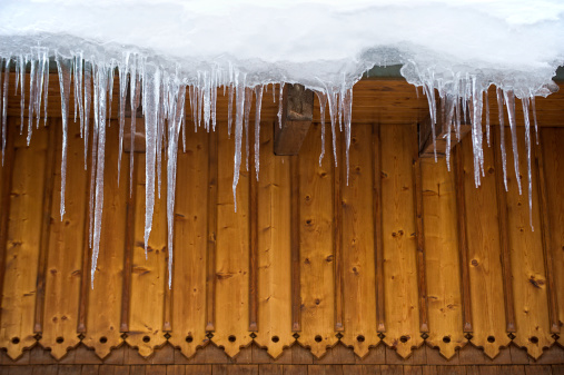 Many icicles hang on roof - with copyspace