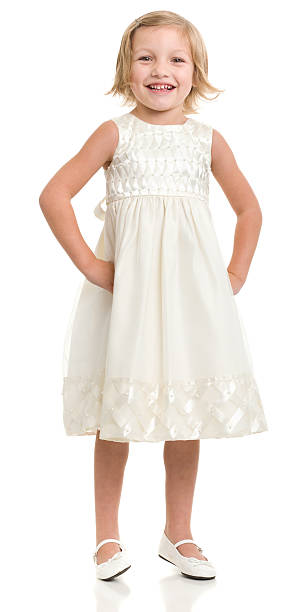 счастливая маленькая девочка, стоя в платье - little girls pre adolescent child standing isolated стоковые фото и изображения