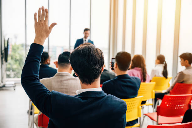 istock Curious individual in a diverse group raises a hand during a conference. This active participation showcases collaboration teamwork and engagement in discussions. 1851268668