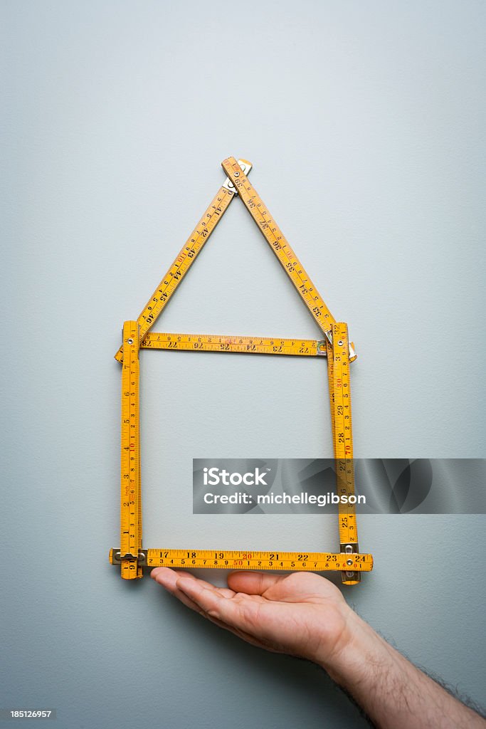 Homem mostrando uma Régua Dobrável em forma de uma casa - Foto de stock de Régua royalty-free