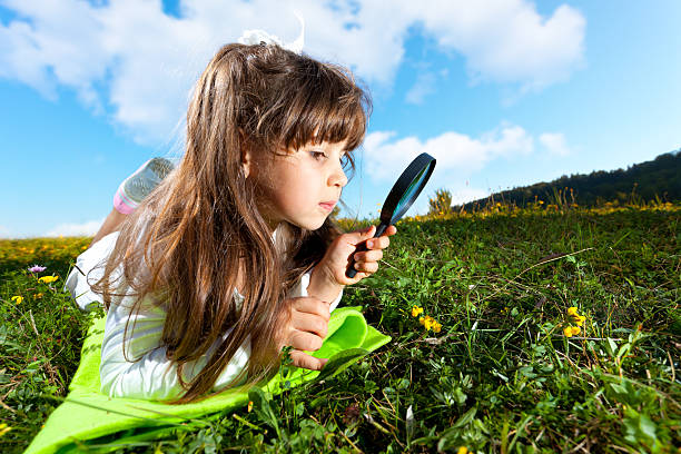 istock Little girl looking through magnifying glass 185127133