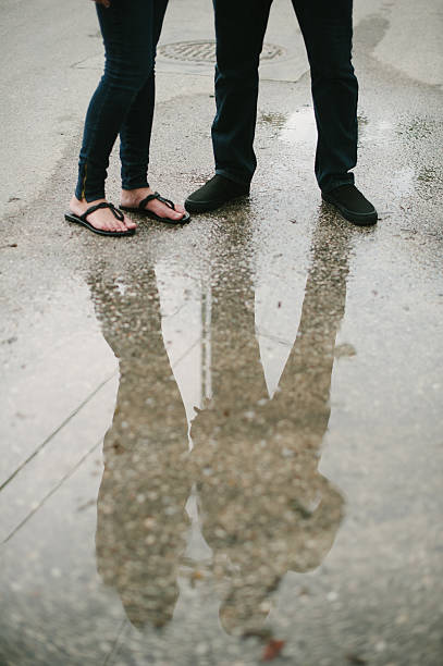 istock Couple standing on street reflection in water. 185127655