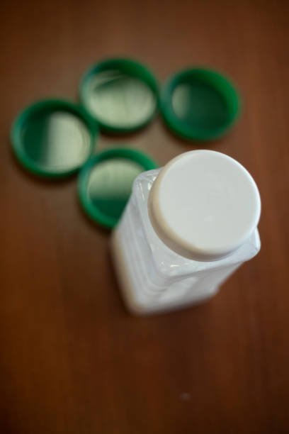 istock Jar of glue on table. Glue in white jar. Green jar lids. 1851278875