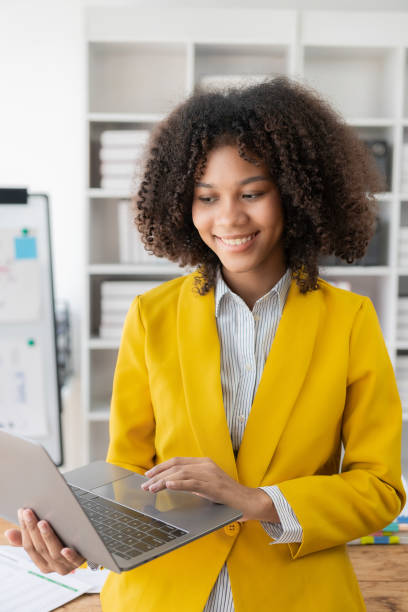 istock Young black woman working with financial documents at home has to use a calculator before paying tax receipt online. Plan your budget to save money. vertical picture 1851306843