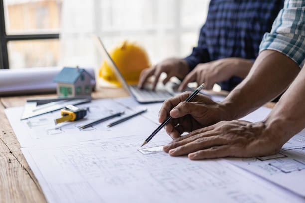 istock Group of engineers and working meeting and discussing construction planning with blueprints with architect equipment. Architects talking at table, teamwork and work flow construction concept. 1851308934