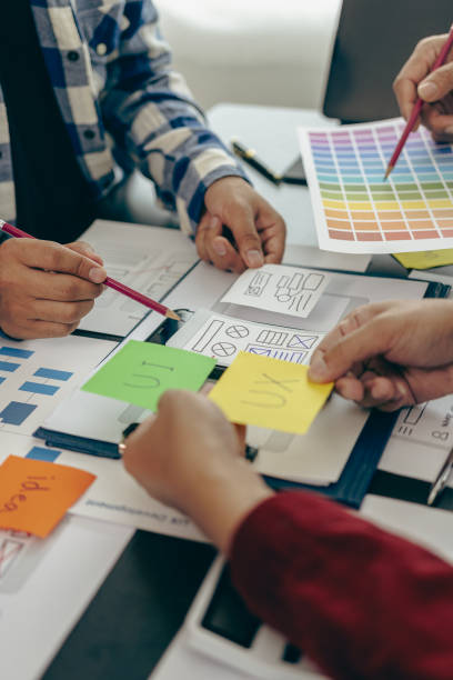 istock UX developers or company employees design user interfaces or UI prototypes for mobile applications or website software that display the software on smartphone screens. Vertical close-up image 1851309978