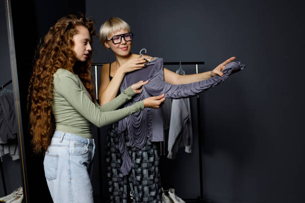 istock Stylist designer helping choose clothes dress to customer client. 1851368164