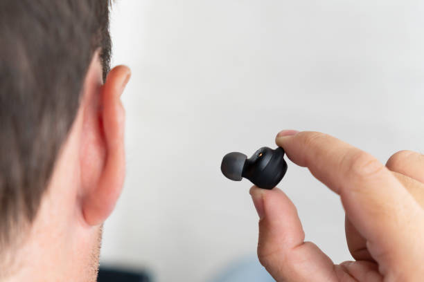 istock Man having wireless headset in the right ear - close up ear . insert earphone into the ear 1851406111